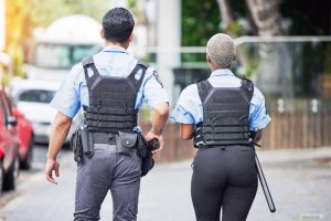 Police, people or walking in city for safety, law enforcement and urban patrol from the back. Man, .